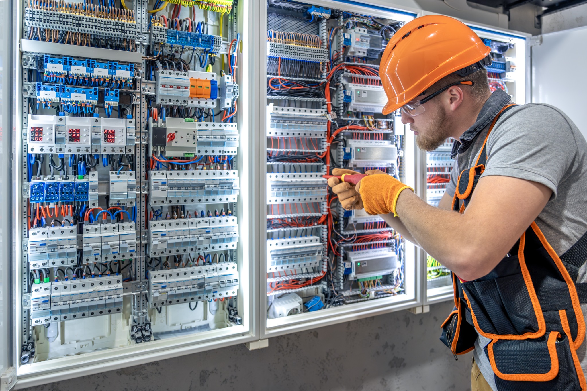 Industrial electrician working on an electrical control panel